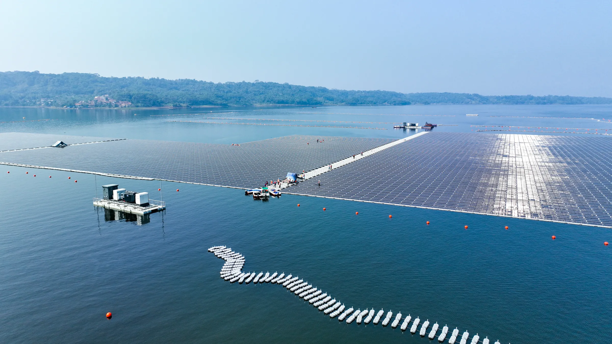 Panel surya terapung Cirata membentang di permukaan waduk dengan perbukitan di latar belakang